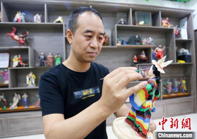 圖為安秋平正在創(chuàng)作代表隴南文縣民俗的《白馬人》作品?！「哒?攝