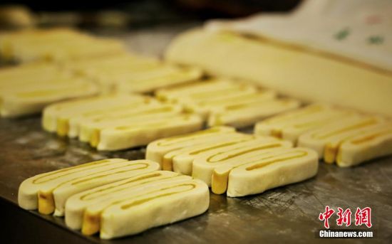 圖為面劑被涂上胡麻油，切成條狀用作月餅的花型制作。張文 攝