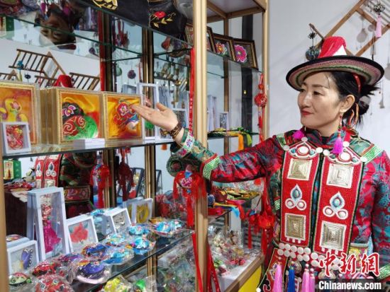 圖為身著民族服飾的隴原巧手展示手工藝品。(資料圖) 徐雪 攝