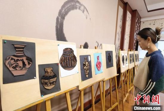 圖為學(xué)生用衍紙材料制作的彩陶紋飾?！⒂裉?攝