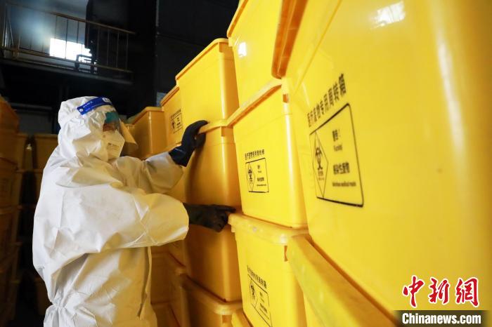 圖為工作人員搬運醫(yī)療廢物專用周轉(zhuǎn)箱?！∥航ㄜ?攝