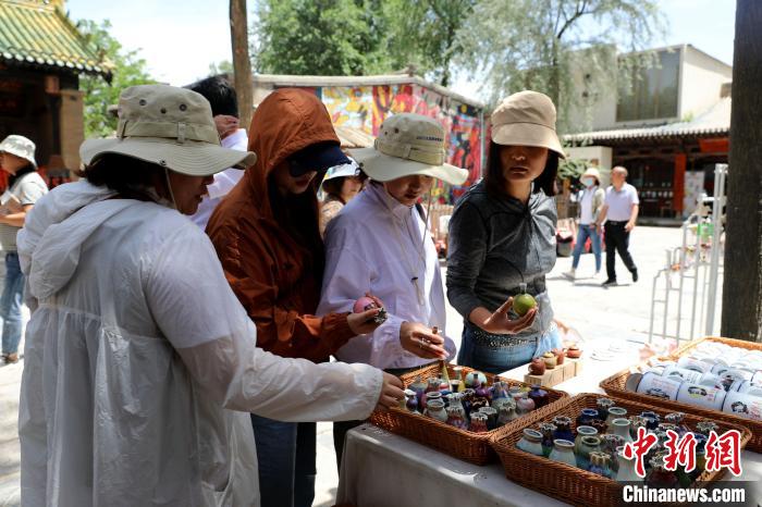 圖為民眾挑選手工藝產(chǎn)品?！⊙Φ?攝