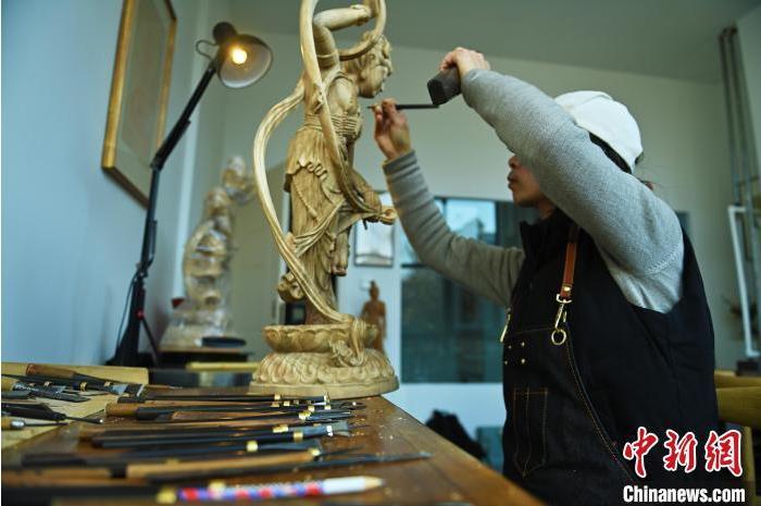 圖為季茂杰進行敦煌元素的木雕創(chuàng)作。李亞龍 攝</p>
<p>