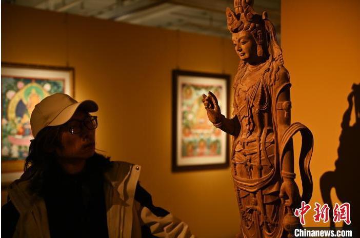 圖為季茂杰觀察自己創(chuàng)作的敦煌木雕。李亞龍 攝</p>
<p>
