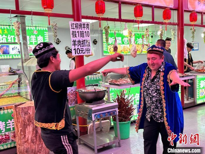 圖為餐飲經(jīng)營(yíng)者在“西涼不夜城”跳起舞蹈引客?！〈魑牟?攝</p><p>