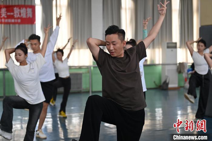 6月6日，在甘肅敦煌青年夜校課程中，青年學(xué)員學(xué)習(xí)敦煌舞課程。李亞龍 攝　　