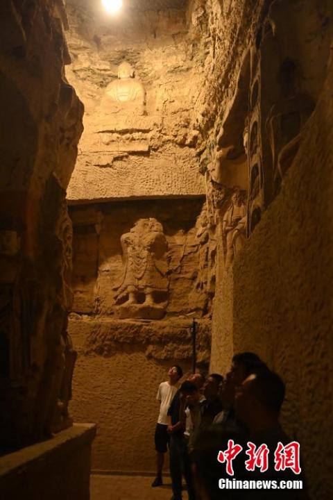 7月15日，游人參觀甘肅省平?jīng)鍪袥艽h百里石窟長廊中的王母宮石窟。百里石窟長廊位于涇川縣境內(nèi)，由512個(gè)石窟、5眼窟中石井組成，現(xiàn)存王母宮石窟、鳳凰山石窟、南石窟寺、丈八寺石窟、羅漢洞石窟、太山寺石窟等規(guī)模較大的石窟群，還有數(shù)量眾多的小石窟群。王母宮石窟又名千佛洞，該窟設(shè)計(jì)宏大，造像生動(dòng)，窟內(nèi)擁有造像數(shù)百尊，是較為珍貴的佛教文化遺存。中新社記者 李亞龍 攝</p>
<p>