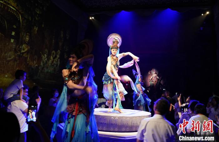 《樂(lè)動(dòng)敦煌》是全球首部洞窟式沉浸體驗(yàn)劇，利用真人與數(shù)字影像虛實(shí)交換實(shí)現(xiàn)沉浸式體驗(yàn)。圖為2023年8月28日晚，《樂(lè)動(dòng)敦煌》演出。(資料圖)中新社記者 毛建軍 攝