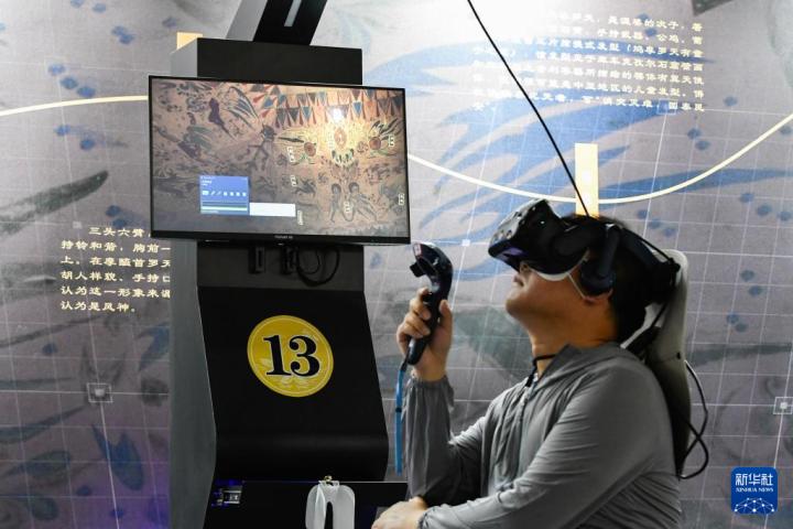 7月22日，游客借助VR設(shè)備沉浸式游覽莫高窟第285窟虛擬場景。新華社記者 郎兵兵 攝